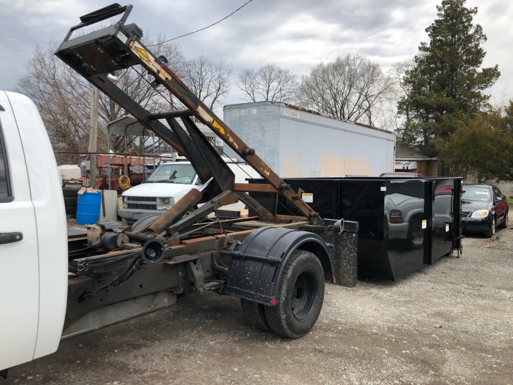 The PLC Hauling truck dropping off a dumpster