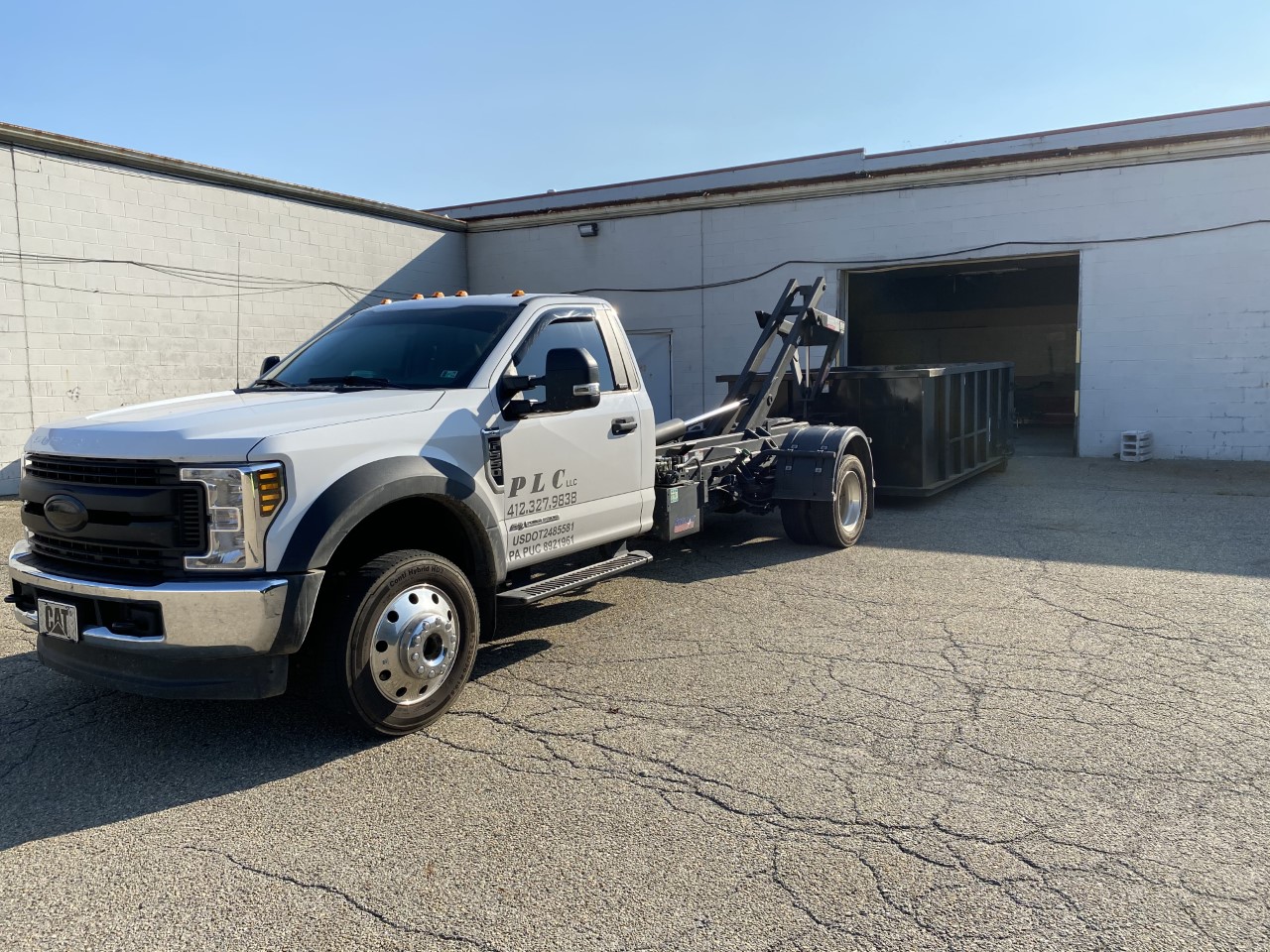 The PLC Hauling truck with a rental dumpster