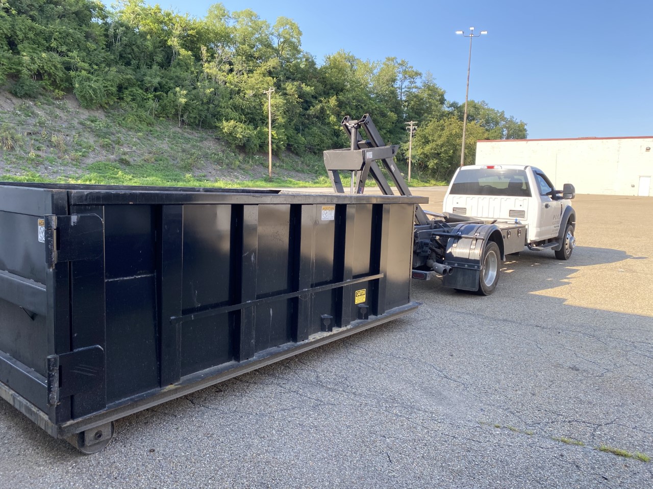 PLC Hauling truck with a black dumpster