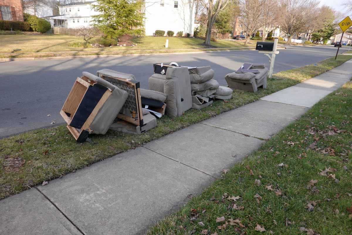 Old furniture set out by the curb in a residential neighborhood